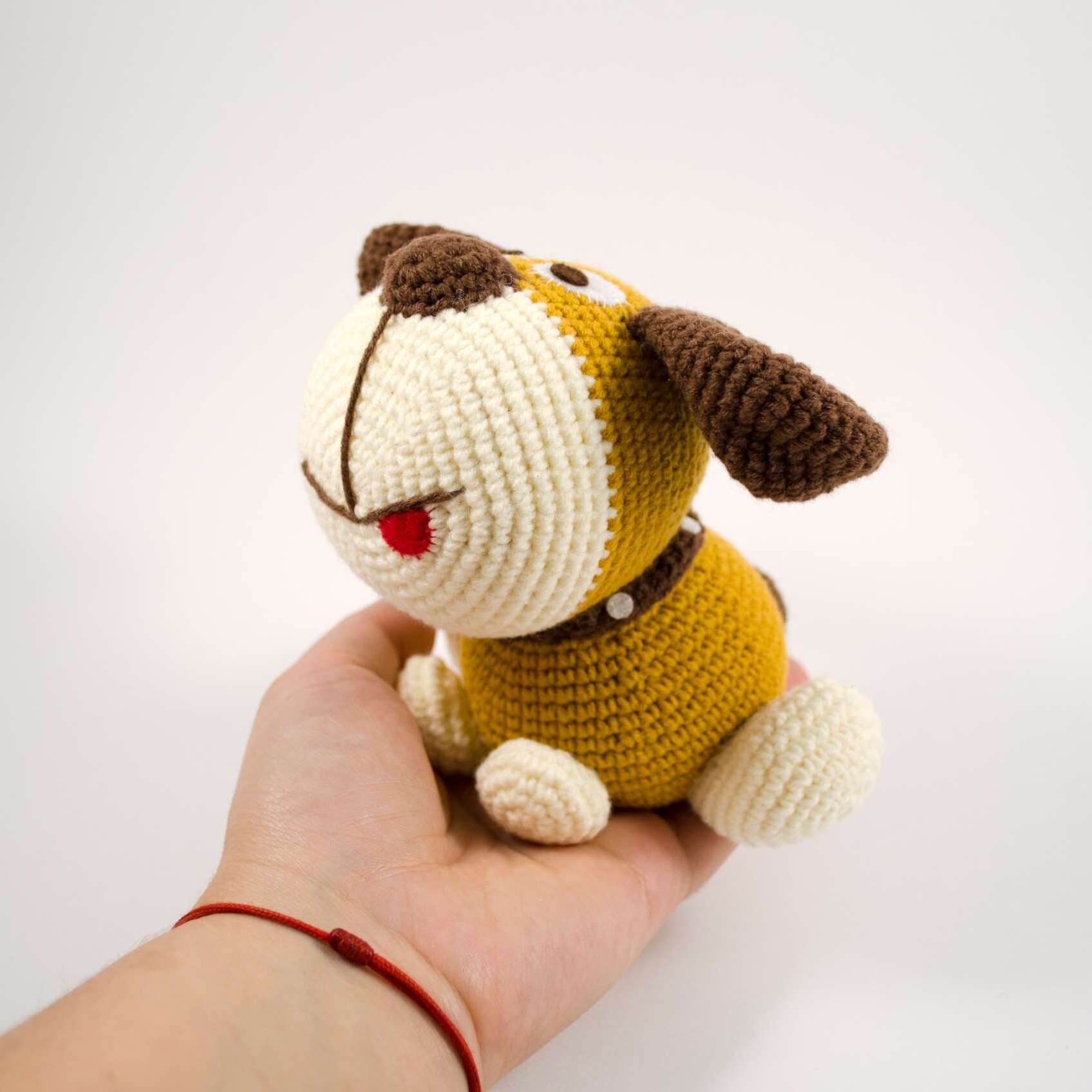holding crochet puppy dog toy
