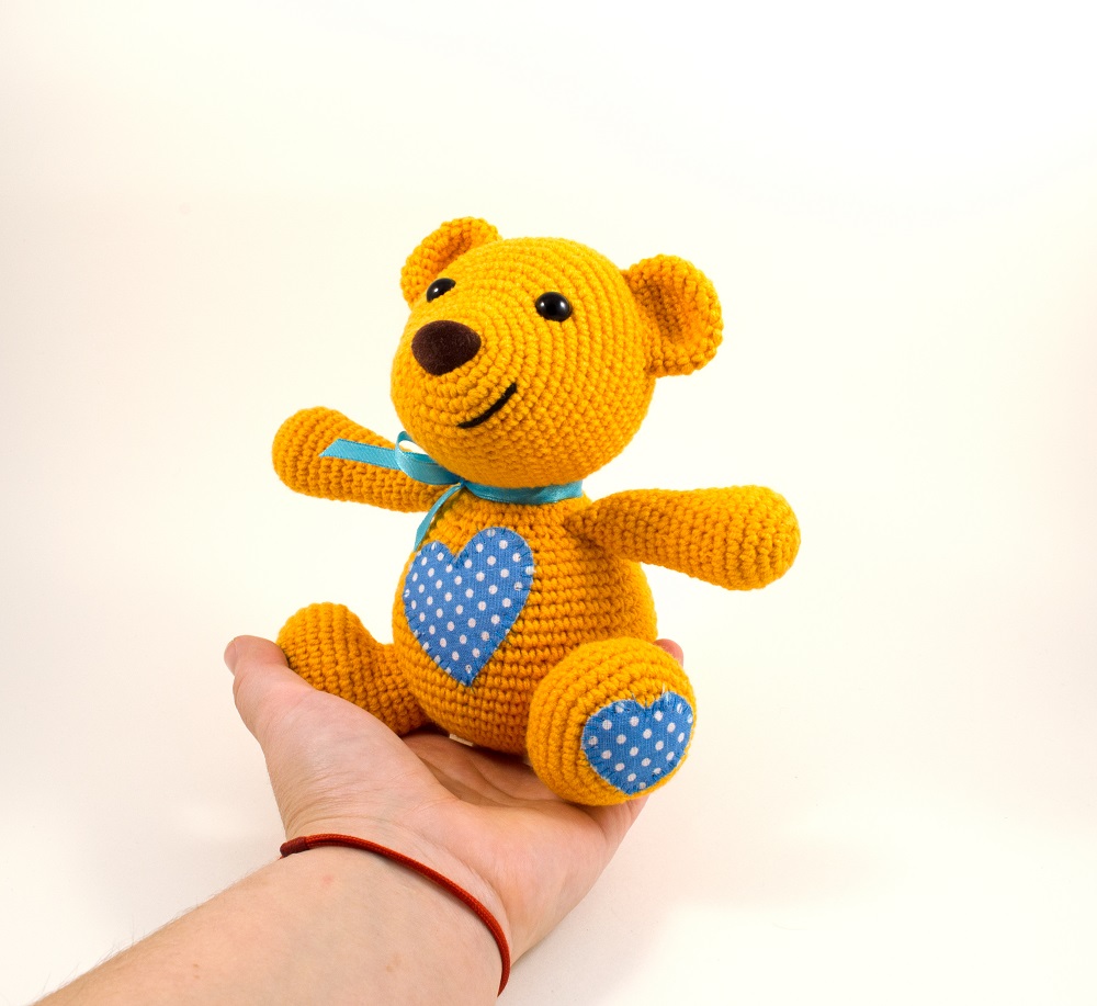 holding in hand crochet teddy bear toy