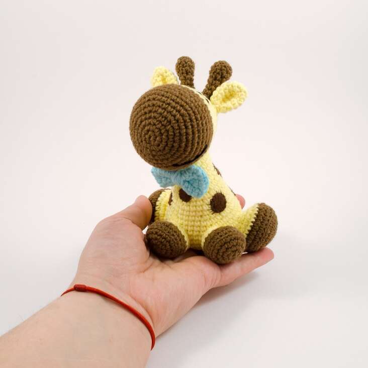 amigurumi giraffe in a hand