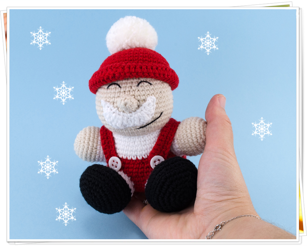 holding in hand crochet santa claus toy