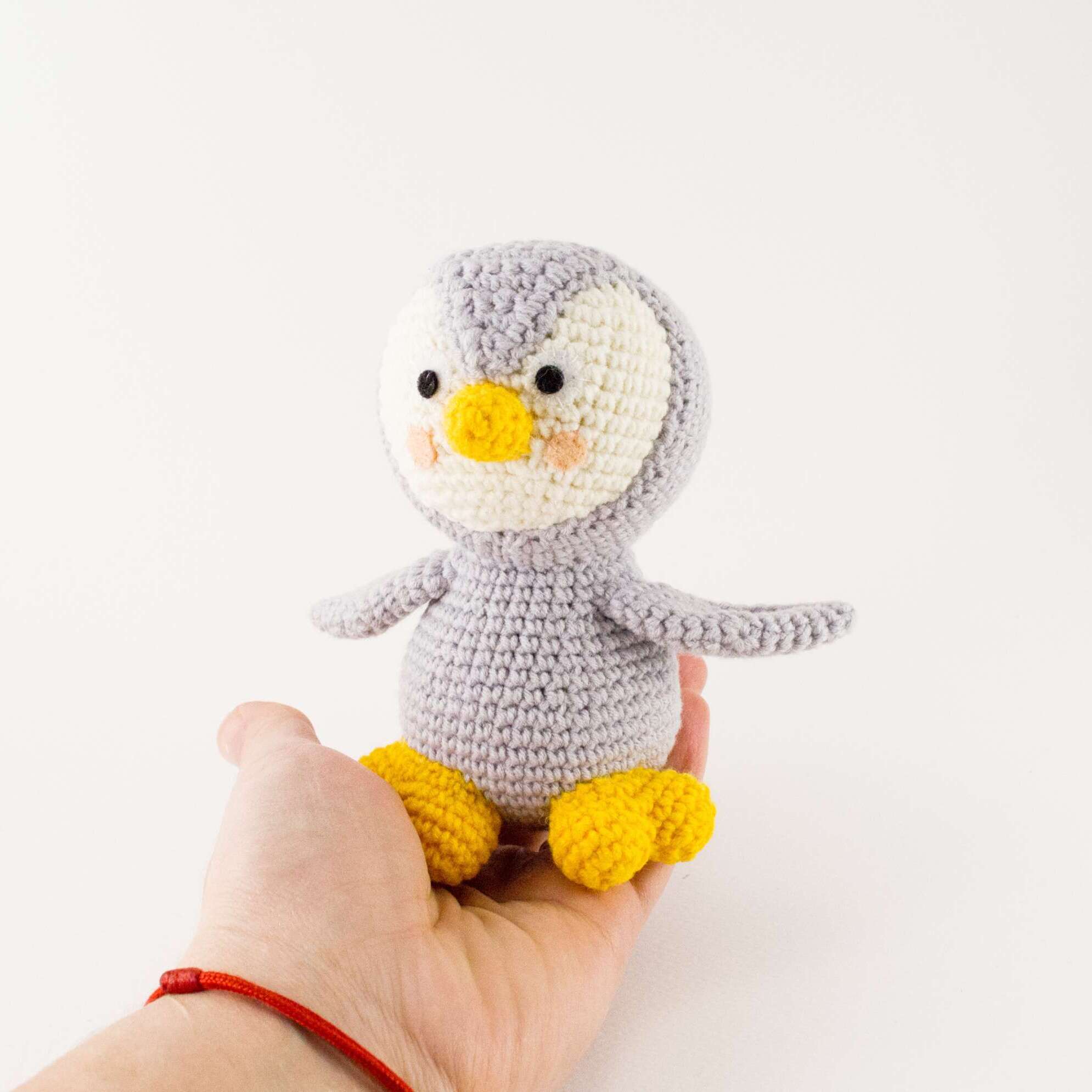 grey penguin in hand